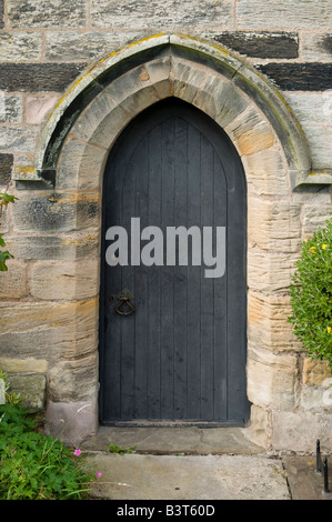 Porta della chiesa e arco in pietra sul Bamburgh in Gran Bretagna Foto Stock