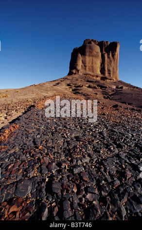 Il Marocco, Ouarzazate, un flusso di lava solidificato con una torre di roccia in background, vicino a Bab n'Ali. Queste formazioni vulcaniche nel Jbel Sahro gamma attira escursionisti provenienti da tutto il mondo. Foto Stock