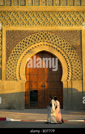 Due donne musulmane a piedi passato il Bab El Mansour in Meknes, Marocco. Completato nel 1732, era una volta la principale via di accesso alla città. Foto Stock