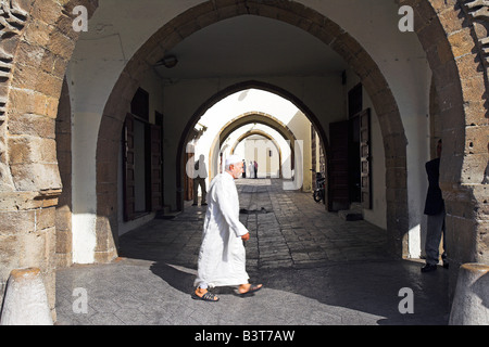 Il Marocco, Maghreb, Casablanca. Un marocchino uomo cammina attraverso il Quartier Habous o 'nuova Medina'. Costruita dai francesi nel 1930, gli architetti hanno provato a sposare il meglio della cucina tradizionale marocchina design con tecniche moderne e strutture. Il risultato è un idealizzato ma attraente versione di un Marocchino tradizionale medina. Foto Stock