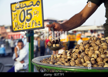 Il Marocco, Tangeri. Lumache in vendita presso uno dei tanti chioschi che riempiono la piazza Djemma El Fna di sera. Foto Stock