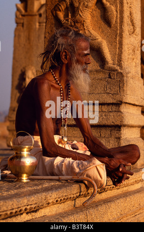 India, Karnataka, Hampi. Un asceta errante o sadhu, appoggia nel portico di un santuario sulla collina Hemakuta Foto Stock