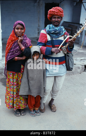 India Rajasthan, Pushkar. Un musicista itinerante - e la sua famiglia giovane - in Pushkar street dove possono guadagnarsi da vivere musicista di strada per i pellegrini che affollano questa città santa. Foto Stock