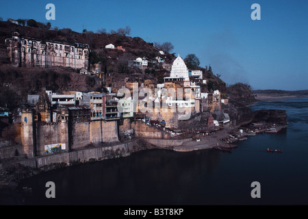 India, Madhya Pradesh, Omkareshwar. Situato su un'isola nel santo Narmada River, Omkareshwar è tra il santissimo spot in India Centrale. Qui il bianco abbagliante guglia di di Shri Omkar Mandhata Tempio si erge al di sopra di un disordine di negozi e bancarelle che vendono paraphernalia religiosa. Foto Stock