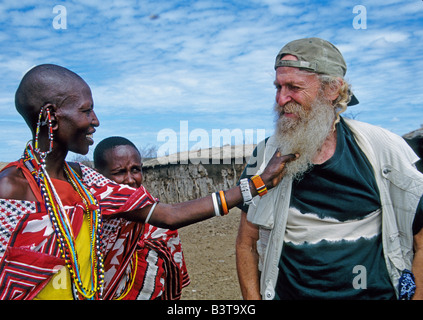 Africa, Kenia Masai Mara National Wildlife Reserve. Due donne in Masai Mara village curioso circa il visitatore con la barba. Foto Stock