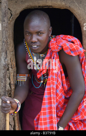 Africa, Kenia Masai Mara. Masai uomo nella porta della capanna tradizionale fatta da bastoni, fango e sterco di vacca. Foto Stock