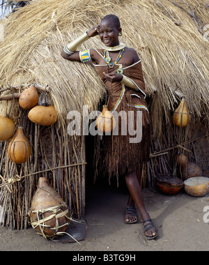 Tanzania Tanzania settentrionale, Manyara. Una donna Datoga rilassa fuori dalla sua casa di paglia. I costumi tradizionali delle donne Datoga Foto Stock