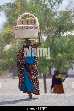 Tanzania, Regione di Arusha, Kwakuchinja. Una donna Maasai porta una culla fatta di doum le fronde delle palme in un variopinto mercato all'aperto Foto Stock