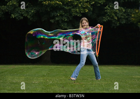 Giovane ragazza che effettuano grandi bolle di sapone Foto Stock