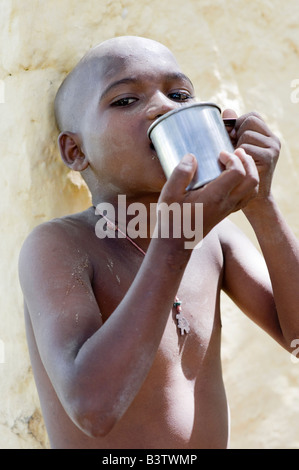 Ragazzo indiano con tazza di metallo, acqua potabile Foto Stock