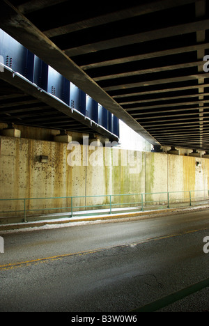 Il sole di setting getta luce sul lato inferiore di questo ponte ferroviario Foto Stock