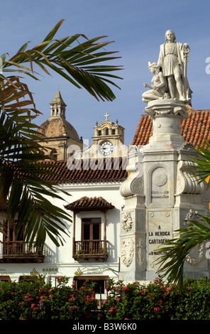 Una statua di Cristoforo Colombo con edifici coloniali spagnoli dietro comprendente una chiesa orologio. Foto Stock