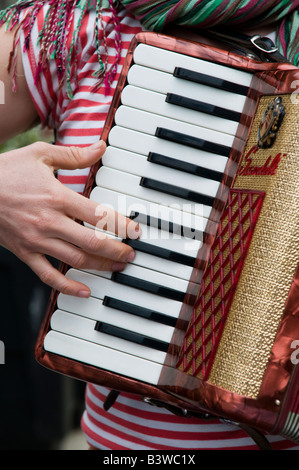 Donna musicista musicista di strada all'aperto suonando piano accordion squeeze box, Wales UK Foto Stock