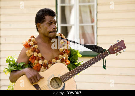 Oceania, Figi, Viti Levu, Viseisei. Ritratto di un uomo delle Fiji in costume nativa in possesso di una chitarra. Foto Stock