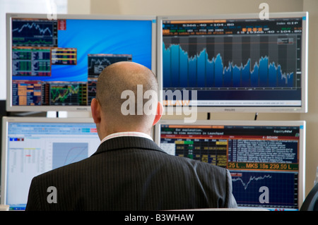 City manager di hedge fund di fronte i grafici finanziari su schermi di computer, London, Regno Unito Foto Stock
