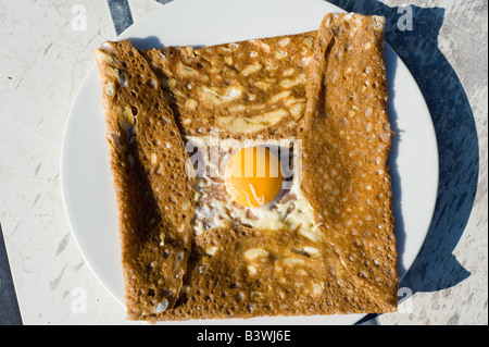 Galette de sarrasin complète, crespa di grano saraceno con prosciutto, formaggio e uova fritte, cucina francese Bretagna, Francia, Europa Foto Stock