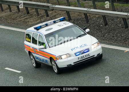 Volvo auto della polizia accelerando lungo una autostrada per un incidente con blue luci lampeggianti e sirena su Foto Stock