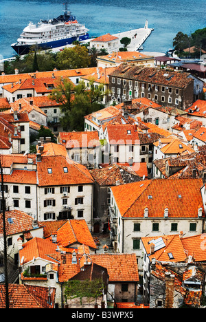 Guardando verso il basso sopra i tetti di Cattaro città vecchia. Nave da crociera ormeggiata in distanza. Montenegro Foto Stock