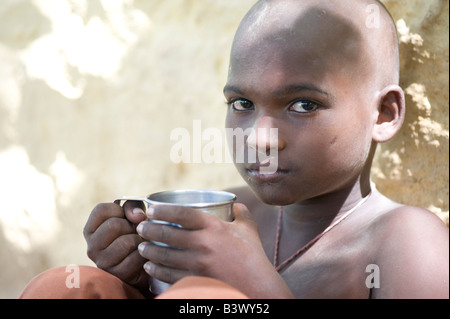 Ragazzo indiano con tazza di metallo, acqua potabile Foto Stock