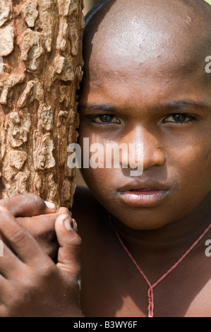 Ragazzo indiano appoggiata ad albero Foto Stock