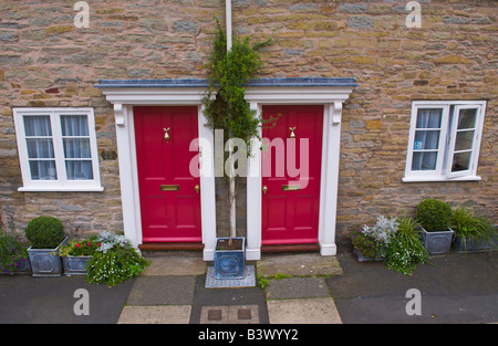 Coppia di identiche porte anteriori su case a schiera a Ludlow Shropshire England Regno Unito Foto Stock