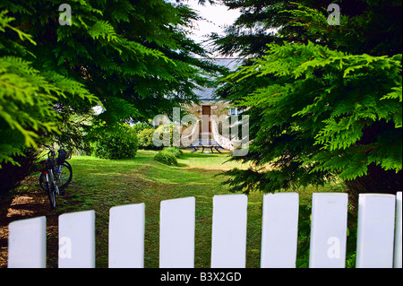 Sbirciando attraverso la recinzione e pini alla casa entrata principale isola di Ouessant Bretagna Francia Foto Stock