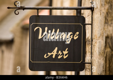 Un segno negozio in un villaggio di Northumberland pubblicizza Village Arte, un negozio di vendita di opere di artisti locali. Foto Stock