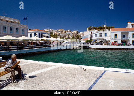 Fisherman seduta oltre il porto di Aghios Nikolaos Creta Grecia Foto Stock