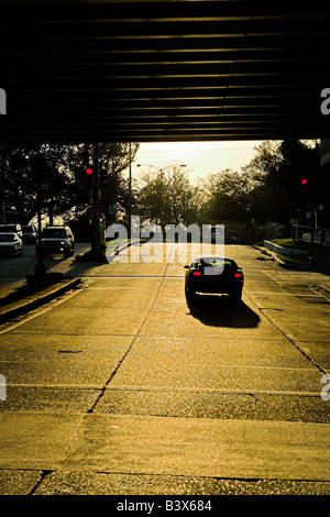 Il sole tramonta sotto I-10 su City Park Avenue (Metairie Road) a New Orleans, Louisiana. Foto Stock