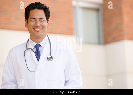 Dottore in piedi al di fuori di un ospedale Foto Stock