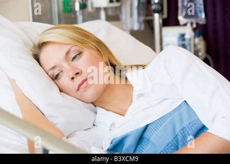 Donna sdraiata nel letto di ospedale Foto Stock