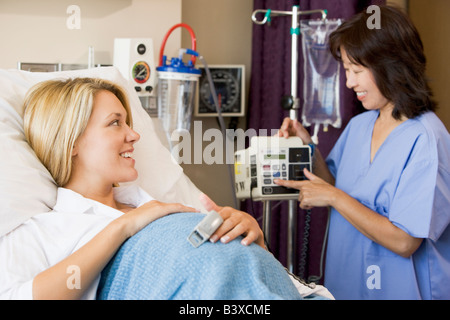 Donna incinta giacente in letto di ospedale Foto Stock