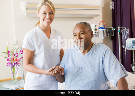 Infermiere Senior aiuta l uomo a camminare Foto Stock