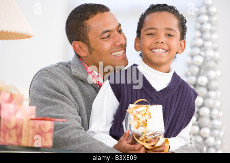 Padre e Figlio abbraccia, tenendo regalo di Natale Foto Stock