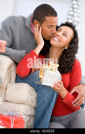 Il marito e la moglie affettuosamente lo scambio di regali di Natale Foto Stock