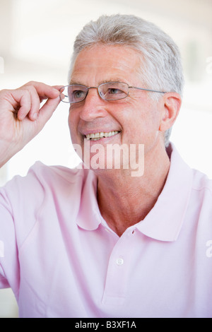 Uomo cerca attraverso nuovi occhiali Foto Stock