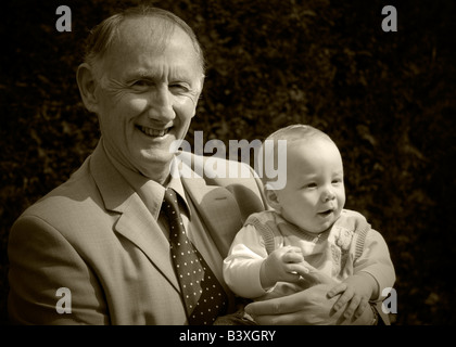 Nonno tenendo la sua nipote ritratto in giardino Foto Stock