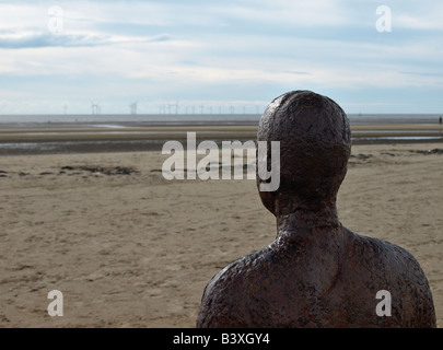 Un altro luogo particolare da uno dei 100 ghisa statue installato su Crosby spiaggia vicino Liverpool artista Antony Gormley Foto Stock