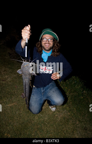 Pescatore con un grande pesce gatto barbell catturato di notte quando si nutrono. Kafue Zambia Africa Foto Stock