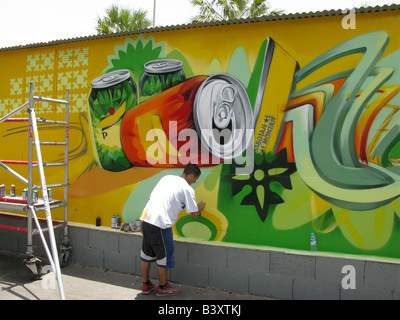 Artista pittura pubblicità un murale sulla parete posteriore di un caffè sulla spiaggia a Playa de Las Teresitas vicino a San Andrés in Tenerife. Foto Stock