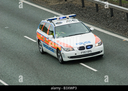 Bmw auto della polizia accelerando lungo una autostrada per un incidente con blue luci lampeggianti e sirena su Foto Stock