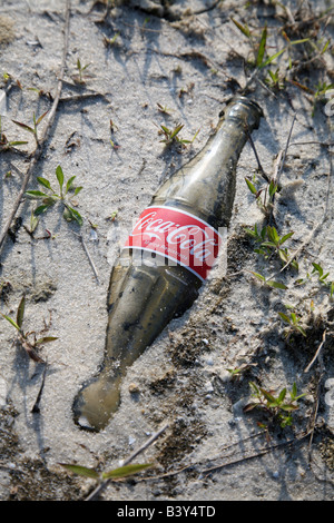 Vetro vecchia bottiglia di Coca sepolto nella sabbia Foto Stock