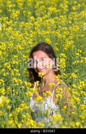 Giovane donna nel campo dei fiori di colore giallo Foto Stock
