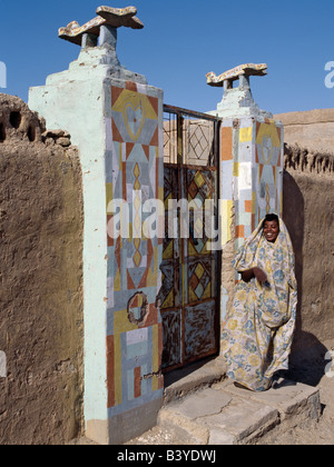 Sudan, il Deserto del Sahara, Qubbat Selim. Una donna Nubiano sorge all'entrata a casa sua. Gli aeroplani su tali stipiti sono stati messi lì perché il proprietario della casa è stato alla Mecca. Essi hanno utilizzato per mettere le barche, ma in età di viaggio aereo il simbolo è cambiato. Foto Stock