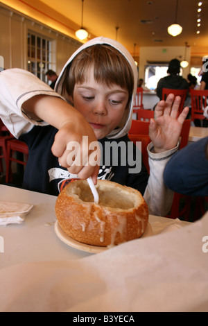 Bambino mangiare clam chowder zuppa di pane di pasta acida ciotola Foto Stock