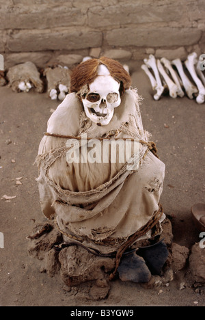 Una mummia Nazca circondato da ceramiche, osso e frammenti di stoffa nel cimitero di Chauchilla in Perù. Foto Stock