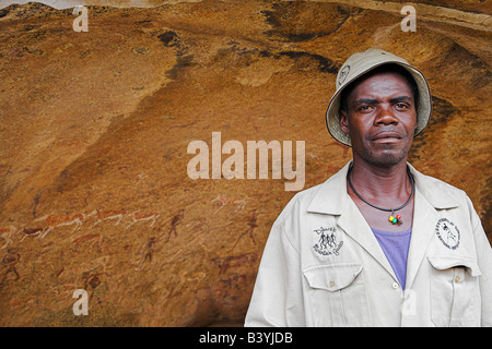 Una guida si erge di fronte alla dama bianca, un 2000 anno vecchio rock boscimane pittura presso Brandberg, Namibia. Foto Stock