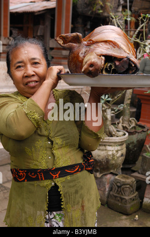 Maialino da latte per galungan festival, donna balinese prendendo il cibo per essere benedetta e come offerte e di Ubud , isola di Bali indonesi , Foto Stock
