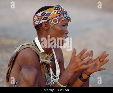 La Namibia, Bushmanland Orientale, Tsumkwe. Un !KUNG donna canta e tubicini le mani al ritmo della sua menfolk. Il !KUNG sono San h Foto Stock