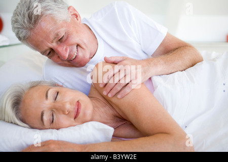 Uomo Donna risveglio giacente in letto Foto Stock